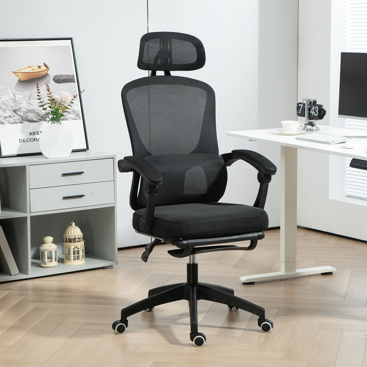 Black reclining mesh office chair with lumbar support and footrest
