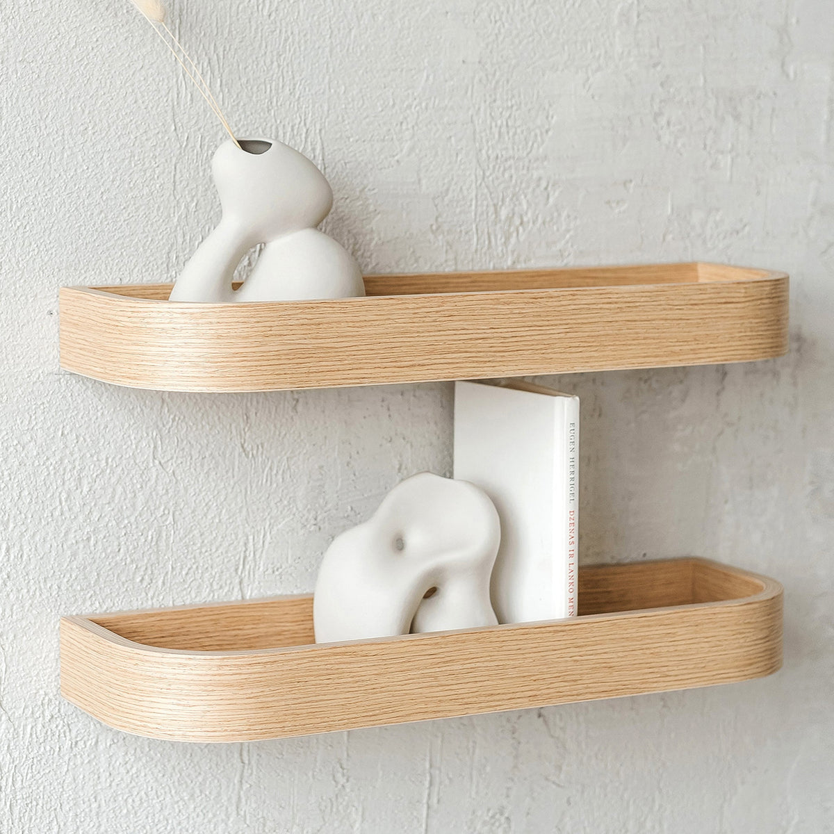 Solid oak floating wall shelves above a minimalist desk